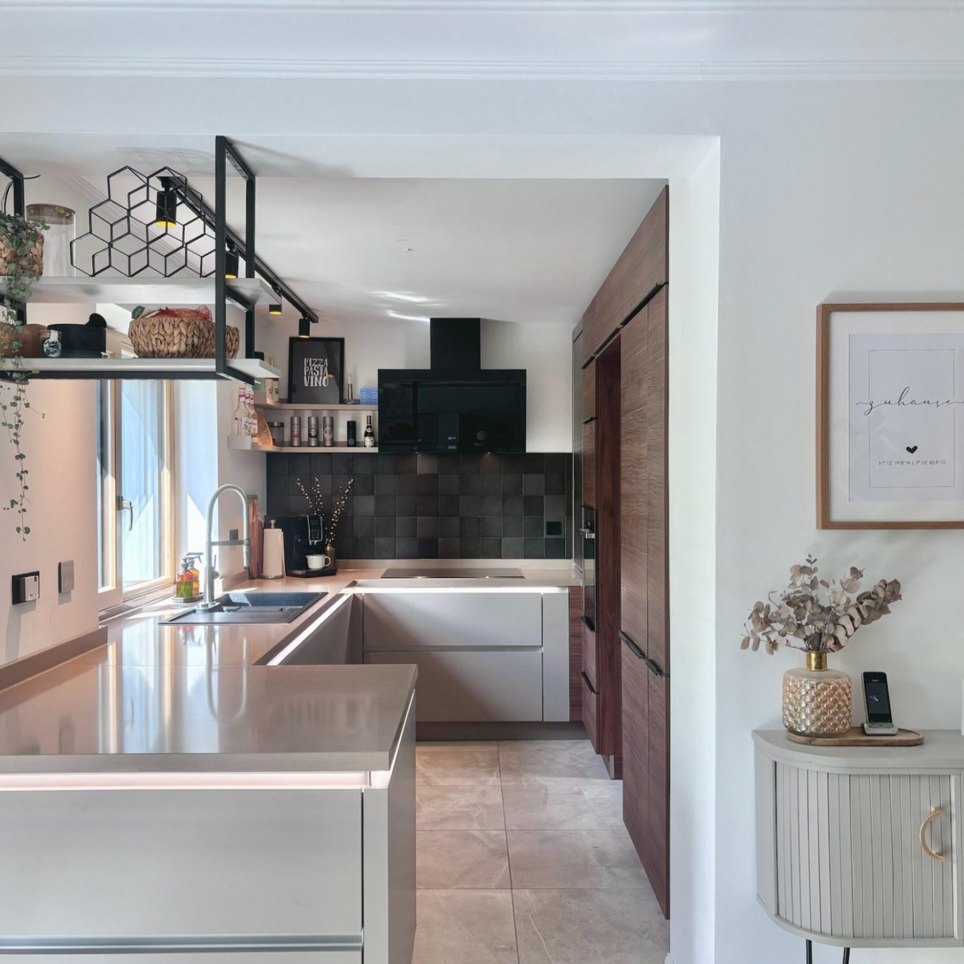 Moderne, helle Küche mit zentralem Kochbereich und eleganten Holzdetails.