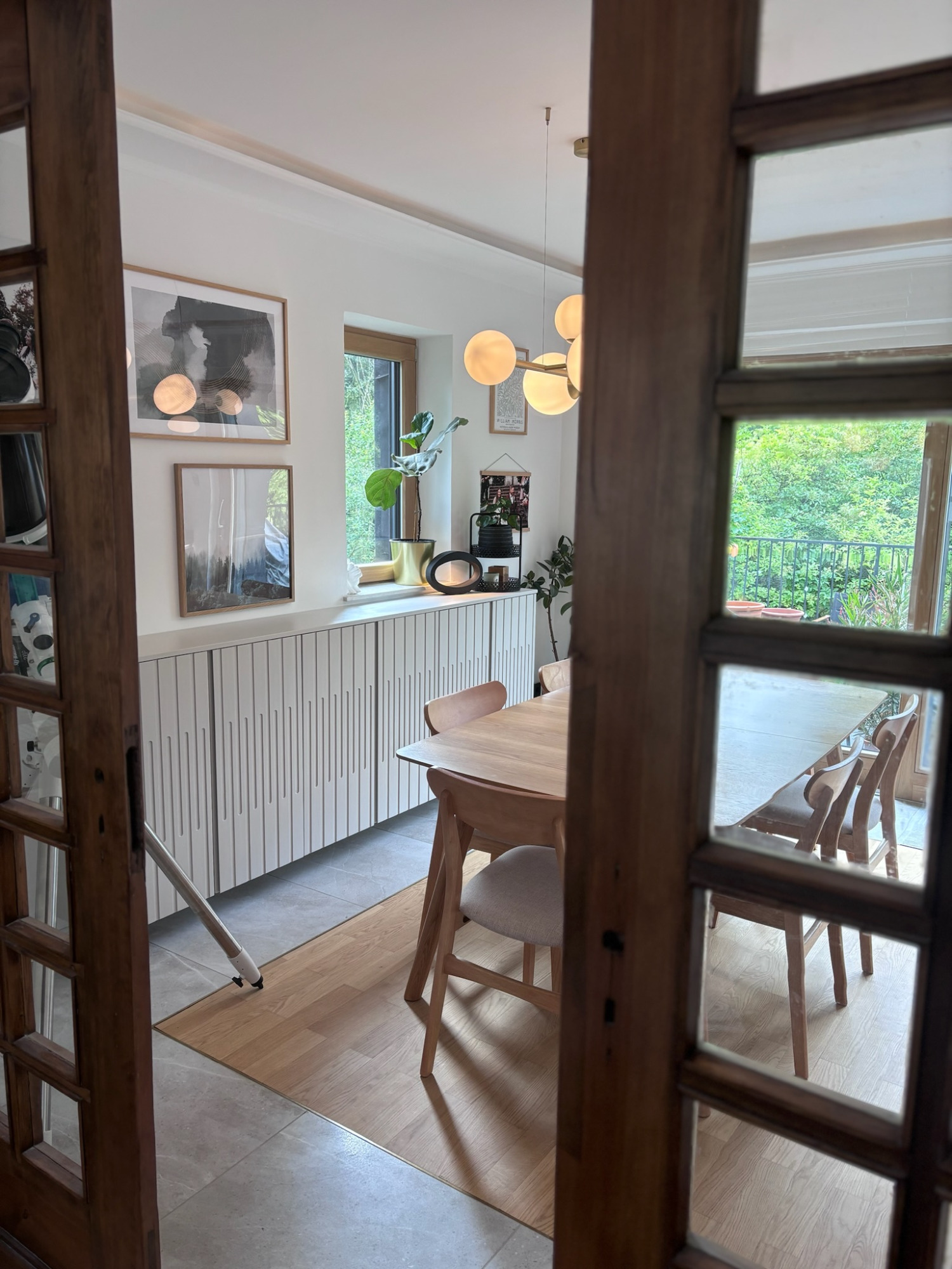 Esszimmer Heller Essbereich mit Holzstuhl und Tisch, umgeben von großen Fenstern und Pflanzen.