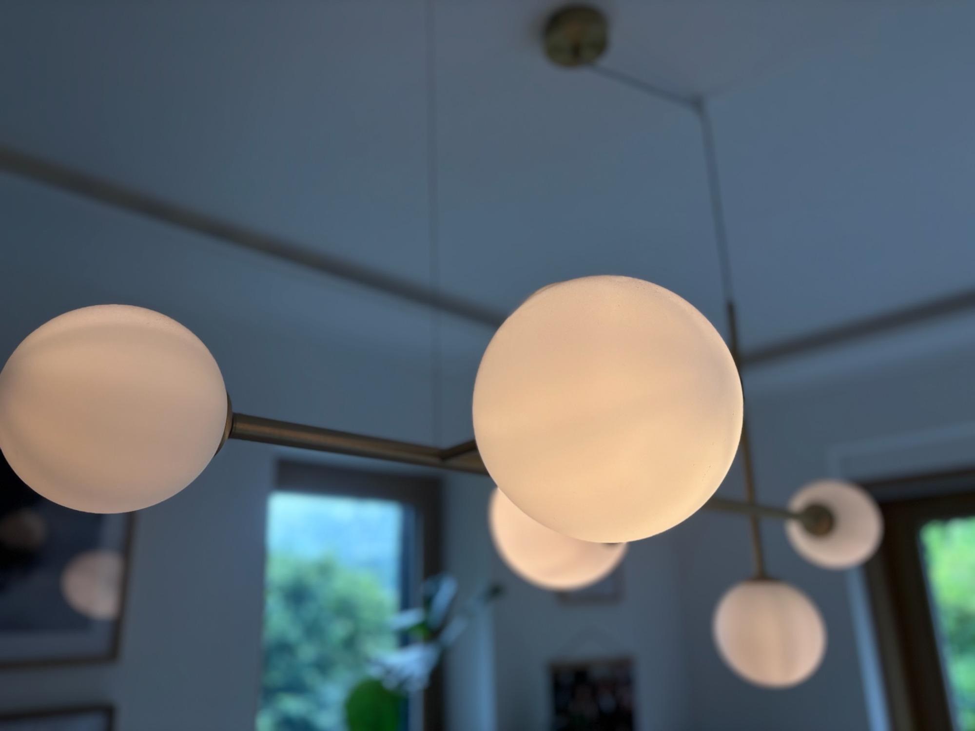 Detail Leuchten Moderne Deckenleuchte mit runden, weißen Lampenschirmen in unterschiedlichen Höhen.